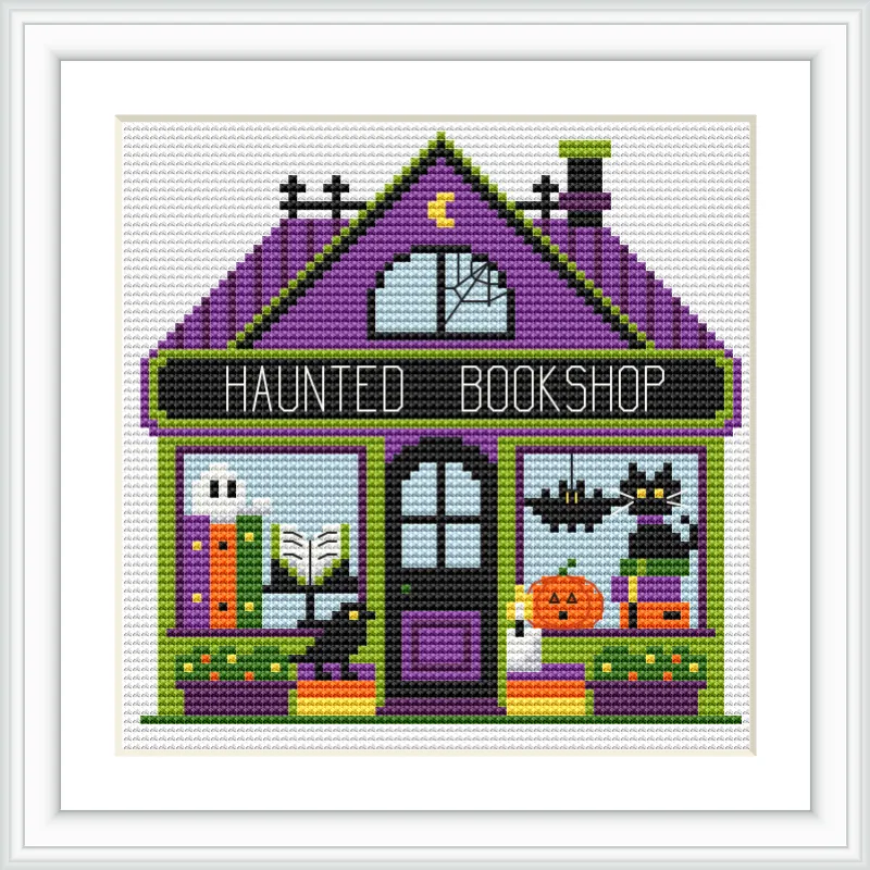 A quaint bookshop with a purple roof, green accents, and a sign reading 'Haunted Bookshop'. Inside, two bats hang from the ceiling, a jack-o'-lantern sits on a shelf, and there are books on display.