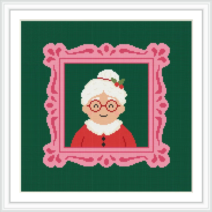 The cross stitch design features a portrait of an elderly woman with white hair in a bun, wearing red clothing and glasses. She is set against a deep green background within a decorative pink frame.