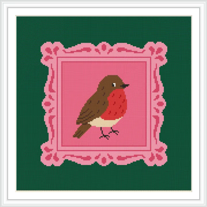 The image features a cross stitch pattern of a robin perched within an ornate pink frame, set against a green background.