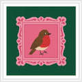 The image features a cross stitch pattern of a robin perched within an ornate pink frame, set against a green background.
