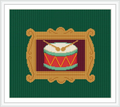 The image shows a decorative frame enclosing a colorful drum with two wooden drumsticks resting on top. The drum features a red and green striped design with yellow accents.
