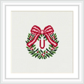 The image shows a decorative wreath made with green leaves and red and white accents, topped with a large red bow, centered around the letter 'U'.