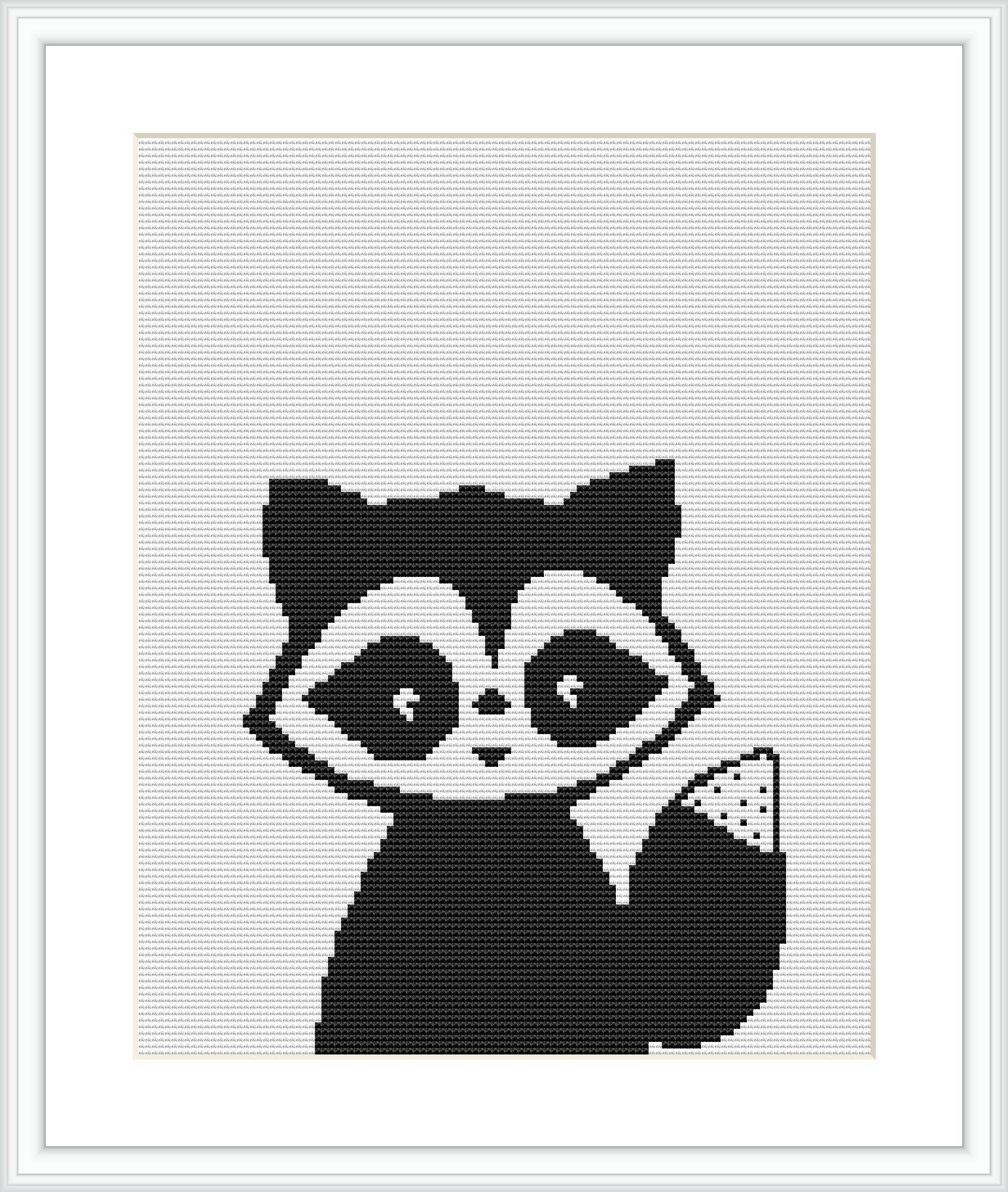 The cross stitch pattern features a stylized raccoon with large expressive eyes and alternating black and white patterns, resembling pixel art. This is framed on a white canvas, ready for embroidery.