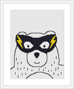 The image features a minimalist cross stitch design of a bear's face with a mask, resembling a superhero. It's centered on a white canvas within a framed presentation.