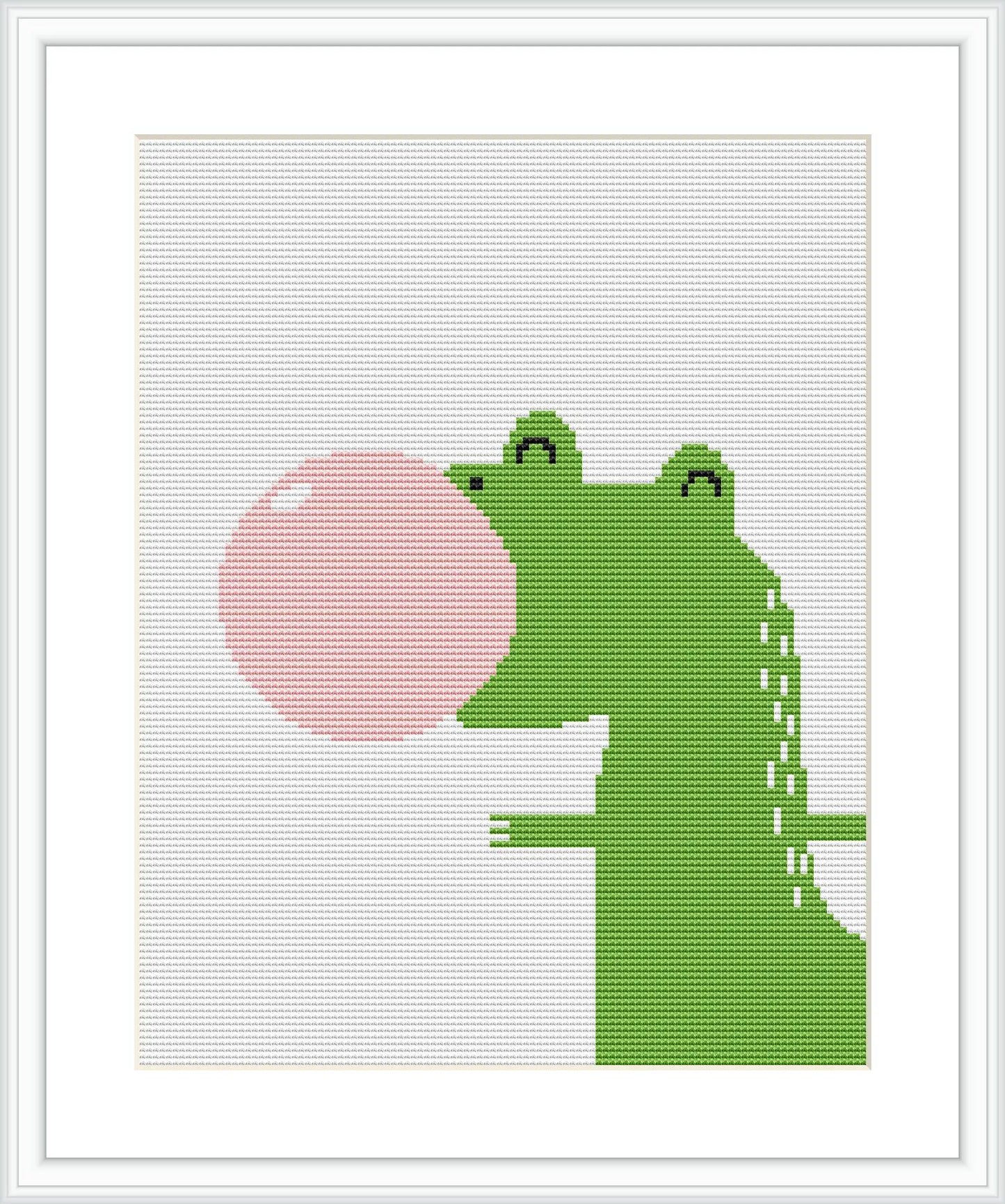 The image displays a framed cross stitch pattern depicting a stylized green dinosaur facing left, blowing a large pink bubble from its mouth. The background is plain white, highlighting the dinosaur and the bubble.