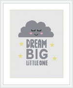 The image depicts a cross stitch pattern featuring a smiling cloud centered above the phrase 'DREAM BIG LITTLE ONE', surrounded by small stars, all stitched onto a white evenweave fabric, framed in a simple white picture frame.