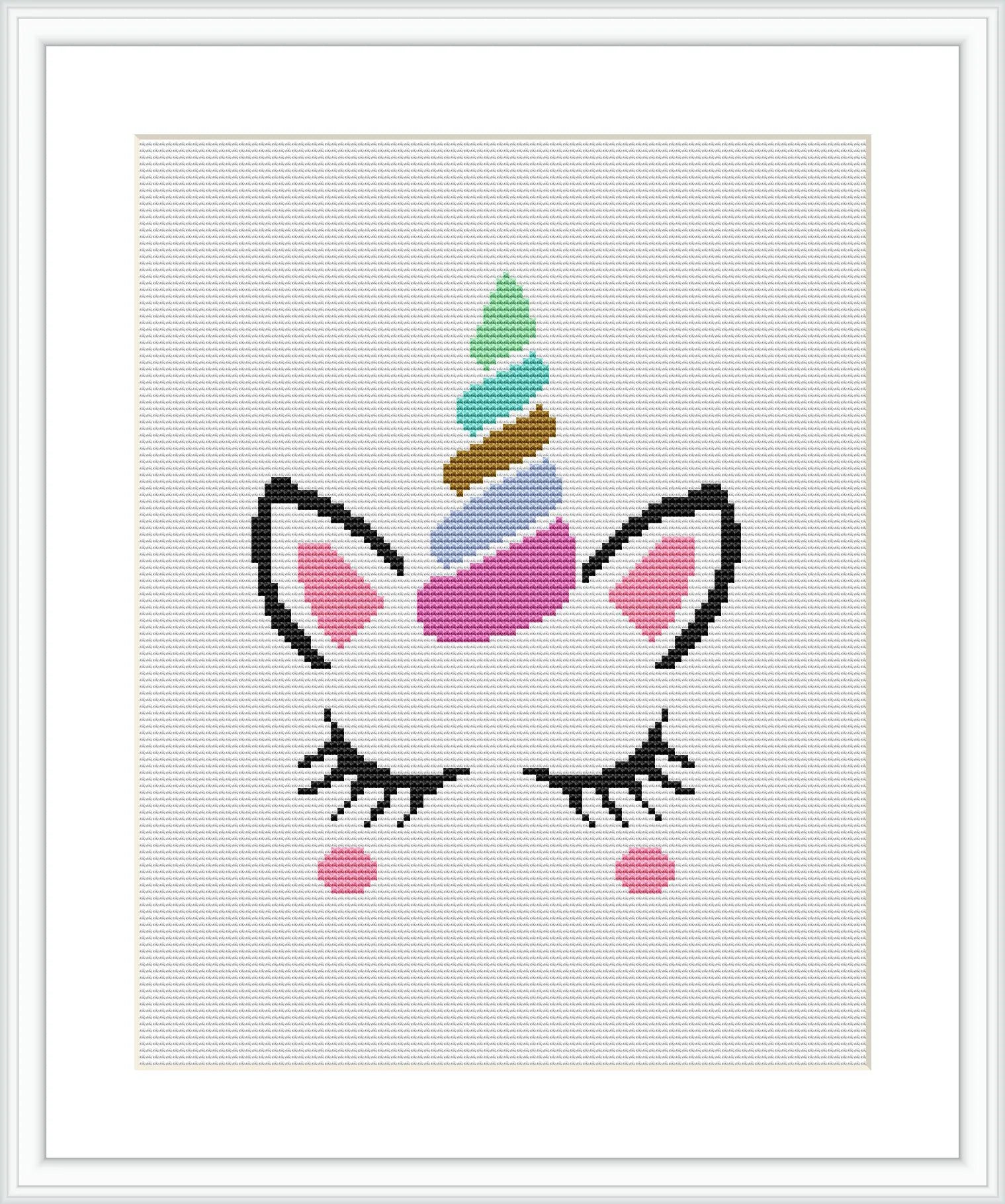 The image shows a framed cross stitch pattern of a stylized unicorn face. The design features a unicorn with closed eyes and lashes, a horn with multicolored swirls, and blushed cheeks. It is centered on a white canvas inside a dark frame.