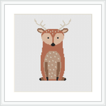 The image shows a cross stitch pattern of a stylized deer centrally placed on a white canvas within a square grid. The deer is depicted with a warm brown and beige color palette and features distinct white spots and black details for the eyes and hooves. The pattern is framed by a simple white border.