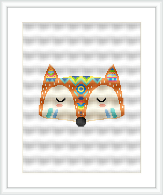 The image depicts a cross stitch design of a stylized fox face with tribal patterns. The design features mirror symmetry, with the fox's eyes closed, centered on a white canvas and framed within a square border.