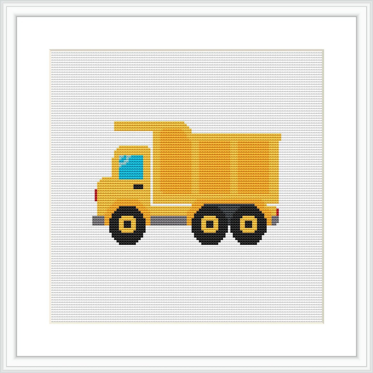 The image features a cross-stitch pattern of a yellow and black dump truck with blue windows on a white canvas. It is framed by a simple white frame, simulating a real-life display of the completed work.