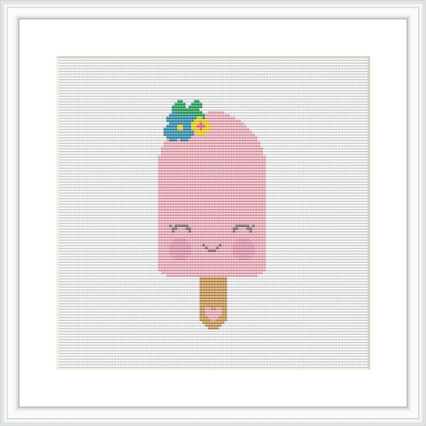 The image depicts a framed cross stitch pattern of a pink popsicle with a smiling face on the popsicle's body. The popsicle stick is brown, and on top of the popsicle, there are what appear to be blueberry and mint leaf embellishments. The design is set against a white aida cloth background, held within a white frame.