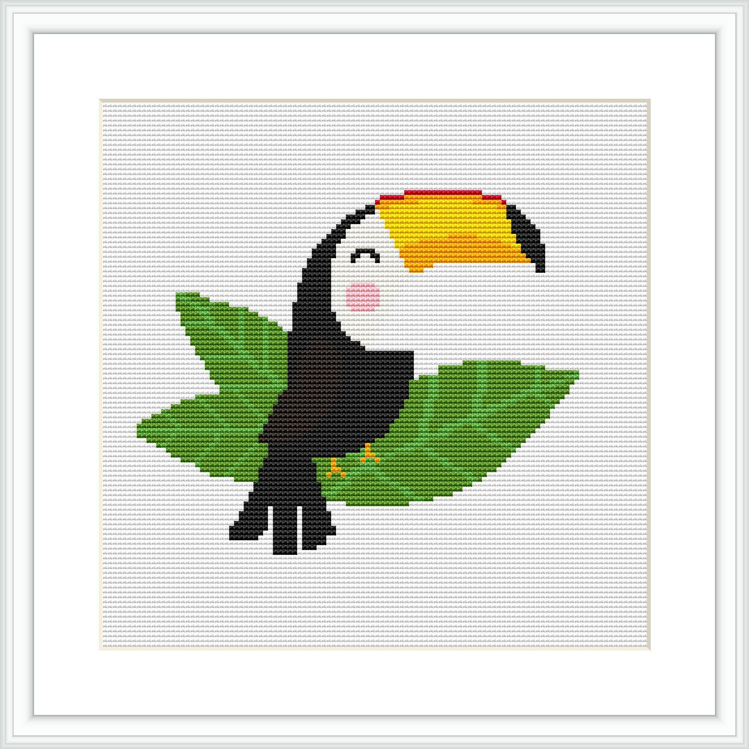 The image shows a framed cross stitch pattern of a cartoon-style toucan perched on a leaf. The pattern grid is visible, and it's displayed against a white background within a square frame.