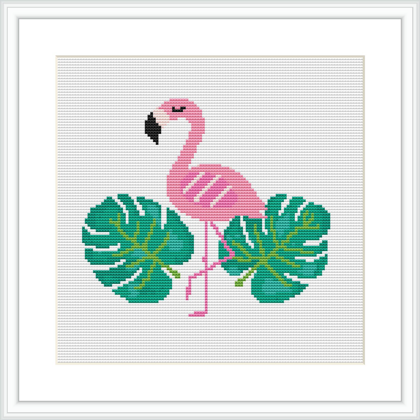 The image displays a cross stitch design of a pink flamingo standing with one leg up, surrounded by two large green monstera leaves. The flamingo and leaves are centered on a white, grid-like fabric within a square frame.