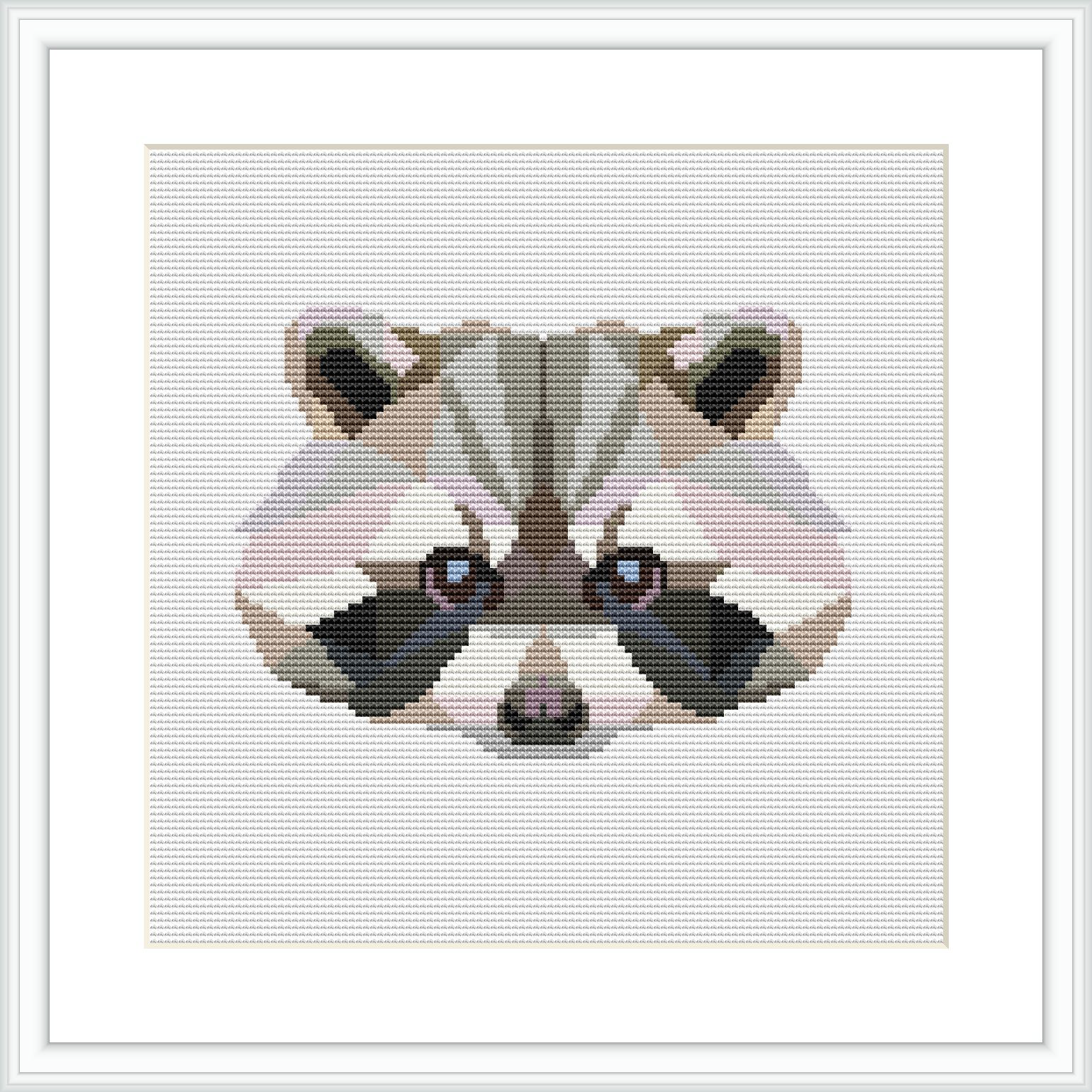 The image shows a framed cross stitch pattern of a stylized raccoon face with geometric shapes and a low poly design, predominantly in pastel pink and grey tones.