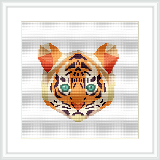 The image is a cross stitch pattern of a tiger's face, centered on a square canvas. The tiger's eyes are strikingly detailed in green, surrounded by fur patterns primarily in orange, black, and white. The pattern is presented within a frame.