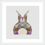 The image showcases a framed cross stitch piece depicting an abstract, geometric representation of a bunny. The bunny is composed of various colorful, pastel geometric shapes set against a white background.