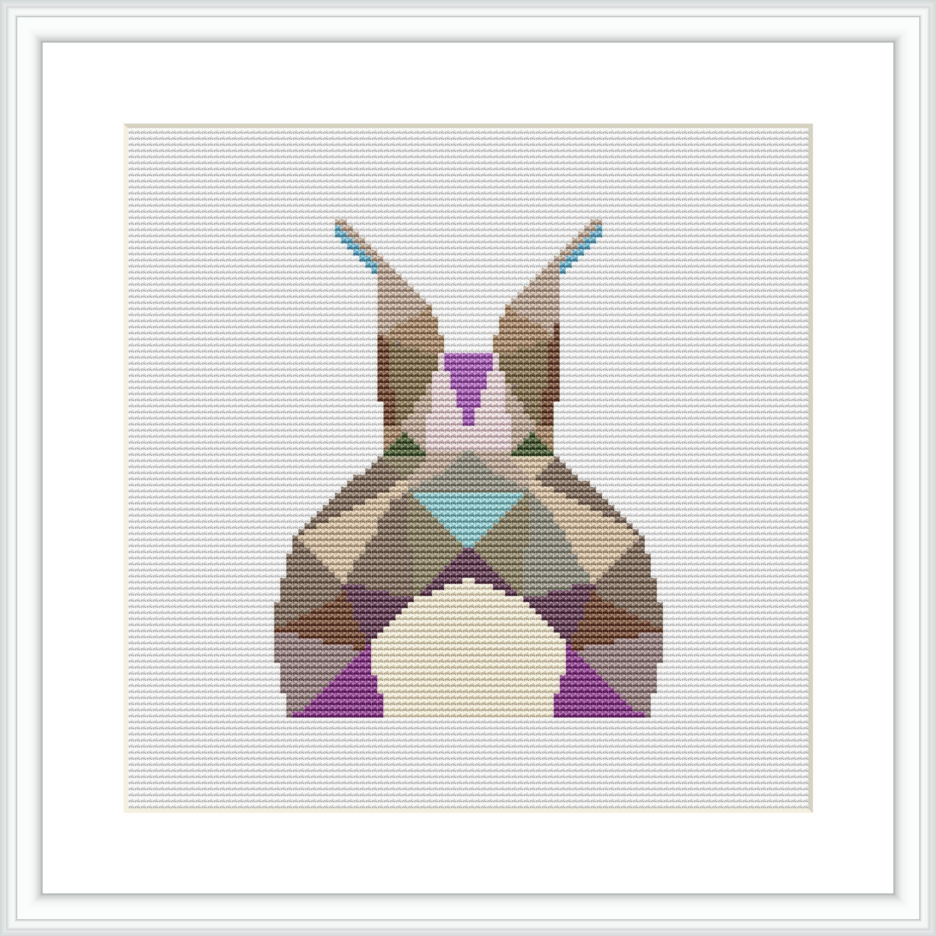 The image showcases a framed cross stitch piece depicting an abstract, geometric representation of a bunny. The bunny is composed of various colorful, pastel geometric shapes set against a white background.