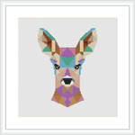 The image features a cross stitch pattern framed in white, depicting a stylized deer head composed of geometric shapes in various colors on a neutral background.