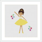 The image features a cross stitch pattern of a ballerina in a yellow dress, with her arms raised gracefully. She is wearing brown ballet shoes and has her hair up in a bun. There are colorful flowers to her right and left on a white background. The overall scene is framed with a simple white border.