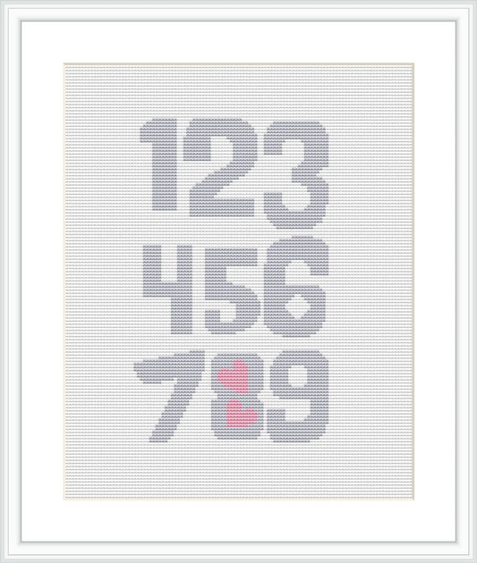 The image displays a cross stitch pattern that features the numbers 1 through 9 arranged in rows with the number 7 and 9 highlighted by pink hearts overlaying them. The pattern is framed, indicating a finished piece.