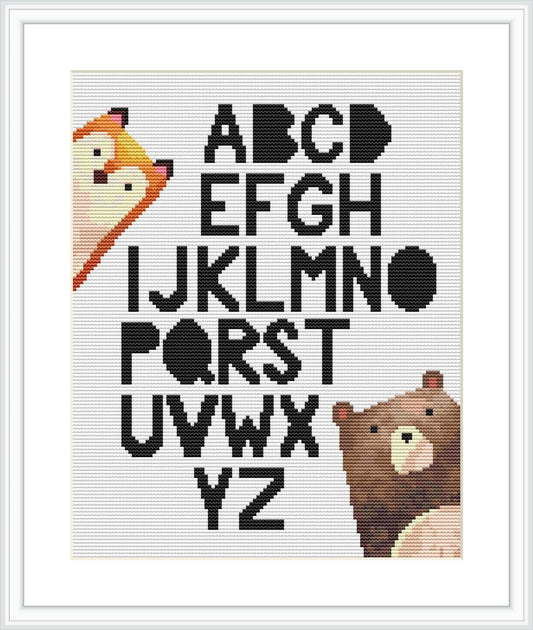 The image depicts a framed cross stitch pattern. It presents a series of letters from A to Z alongside cartoon-style animals, with each animal uniquely representing a letter. The background is white, and the pattern is encased in a simple frame.