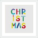 The image depicts a cross stitch design featuring the word 'CHRISTMAS' spelled out in block letters, each letter a different vibrant color, on a white cloth displayed within a square frame.