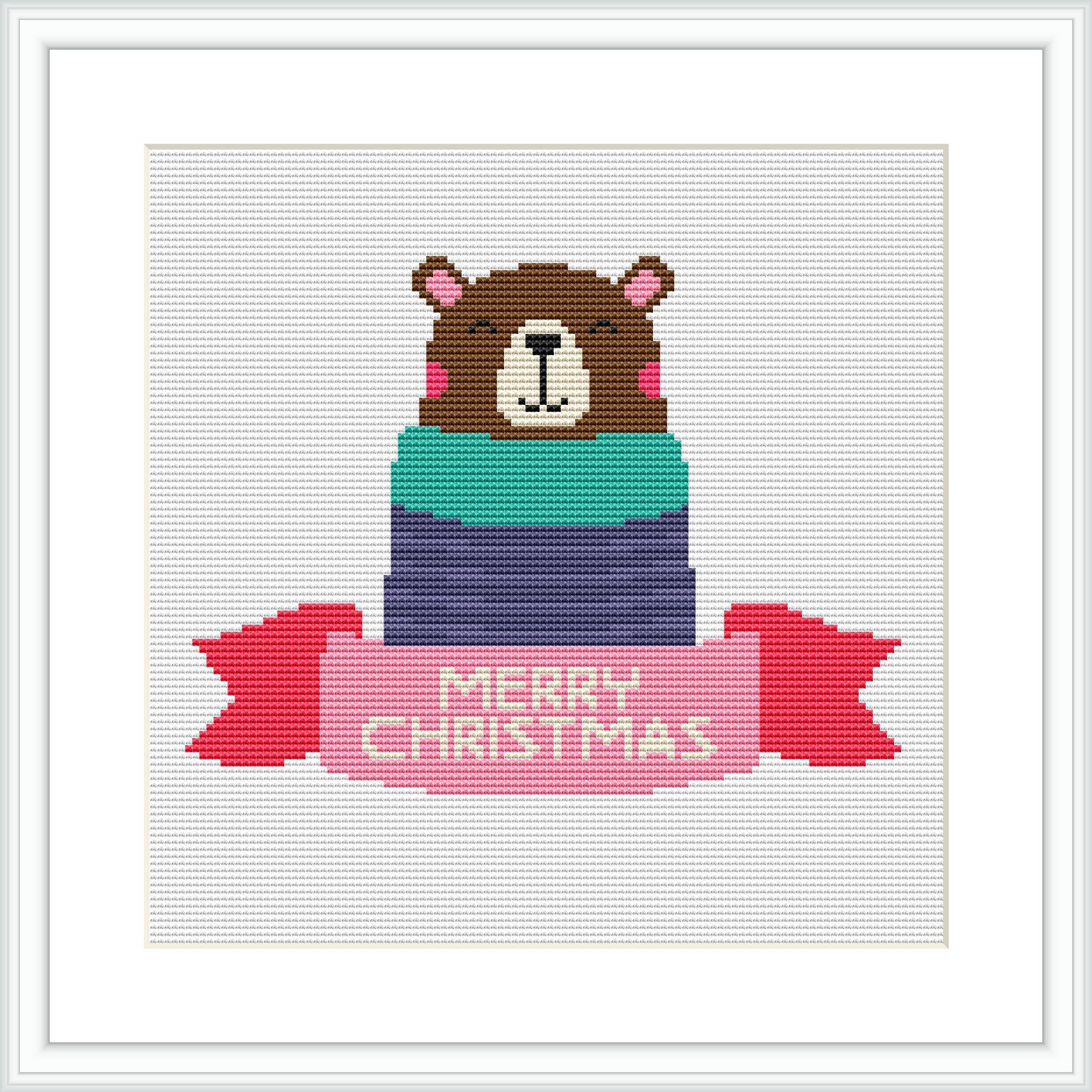 The image shows a cross stitch design featuring a brown bear wearing a pink Santa hat and partially wrapped in a gift box with layers of green, blue, and purple. The words 'MERRY CHRISTMAS' are stitched in red on a banner below the bear.