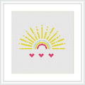 The image displays a framed cross stitch pattern design of a semi-circular sun with yellow rays extending outward at the top and three heart-shaped pink flowers at the bottom, all against a white background.