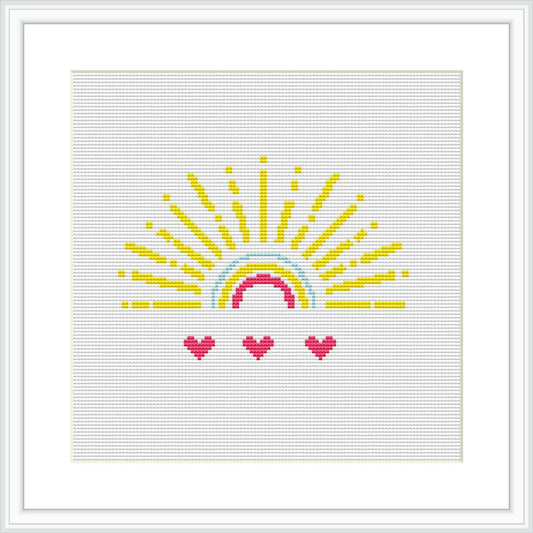 The image displays a framed cross stitch pattern design of a semi-circular sun with yellow rays extending outward at the top and three heart-shaped pink flowers at the bottom, all against a white background.