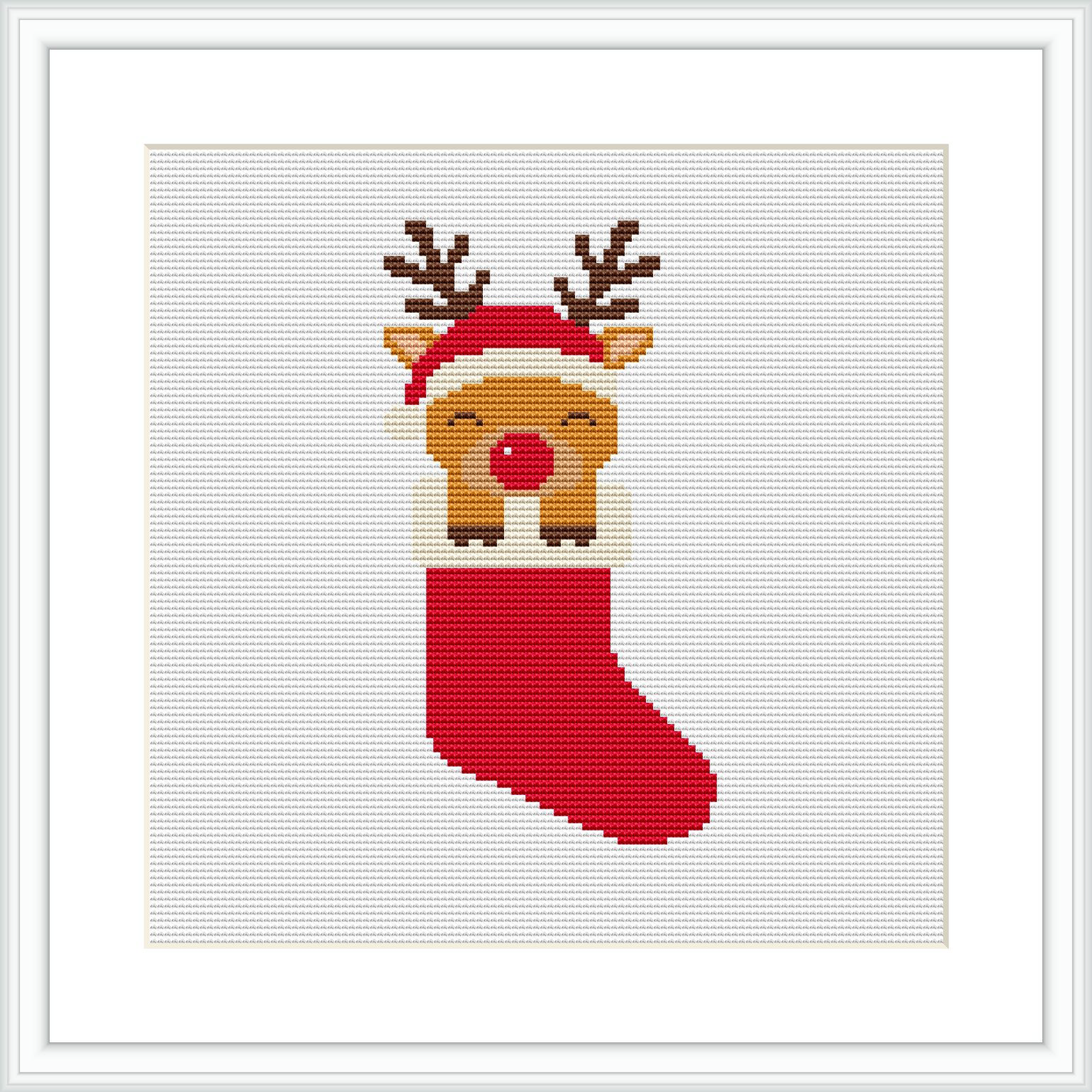 The image depicts a cross stitch pattern of a cute reindeer with antlers and a red nose, poking its head out of a red holiday stocking. The stocking and the deer are centered on the canvas, surrounded by a minimalistic white background, framed in a simple white frame.