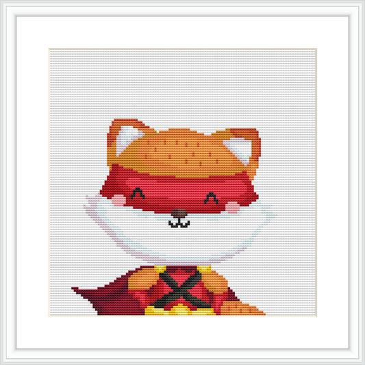 The image features a cartoon-style fox character dressed as a superhero with a red cape. The fox is facing forward with a playful expression, against a plain white background. It's framed in a simple black frame, suggesting it's a finished cross-stitch piece.