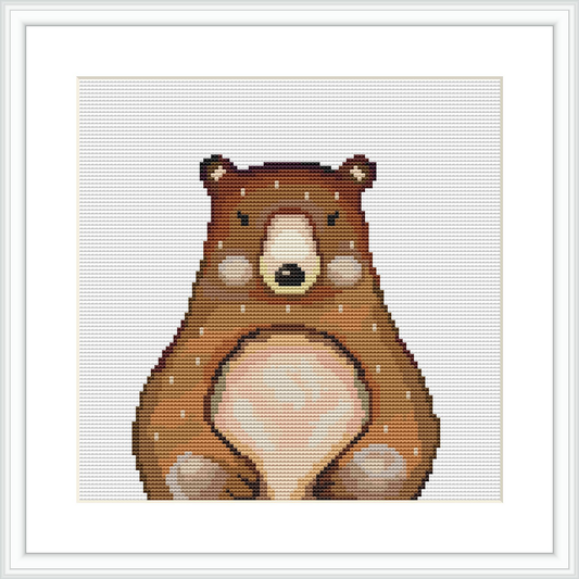 The image shows a cross stitch pattern featuring a bear standing up with its front paws together, set against a white background. The pattern is framed within a simple white square frame.