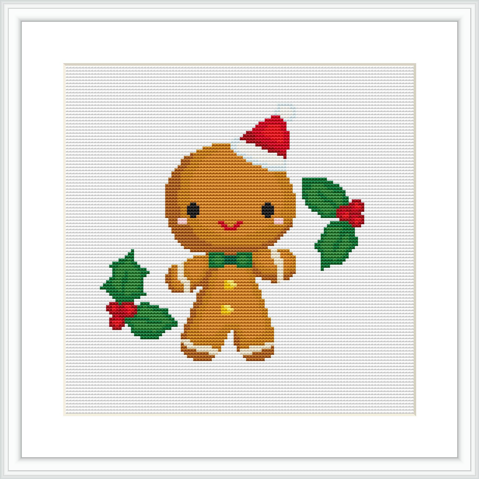 The image depicts a finished cross stitch pattern of a gingerbread man with a Santa hat, smiling, and holding a green and red holly branch. The pattern is displayed on a white canvas and framed with a simple, thin white border.