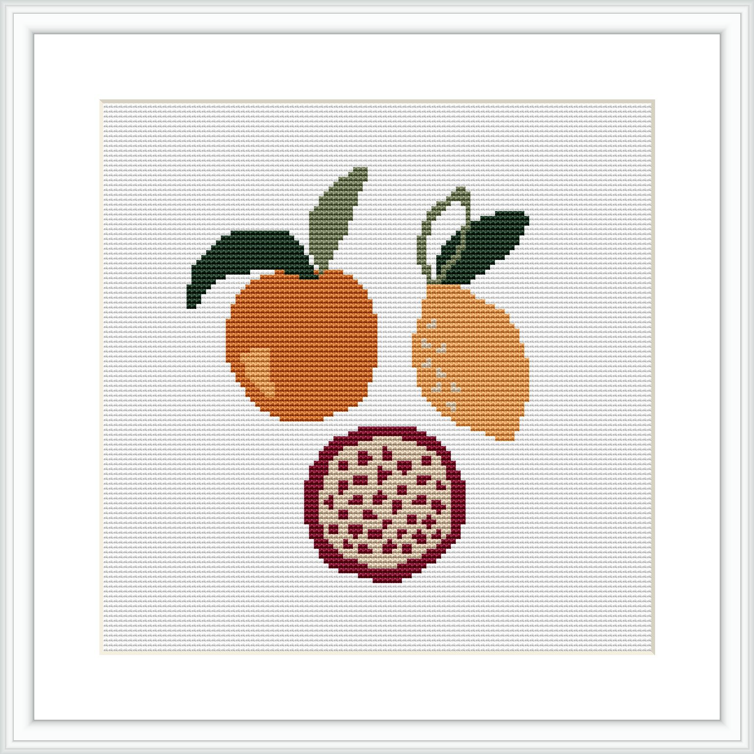 The image presents a framed cross stitch pattern with three fruits displayed vertically; an orange at the top, a lemon in the middle, and a cross-sectioned pomegranate at the bottom set against a white background.