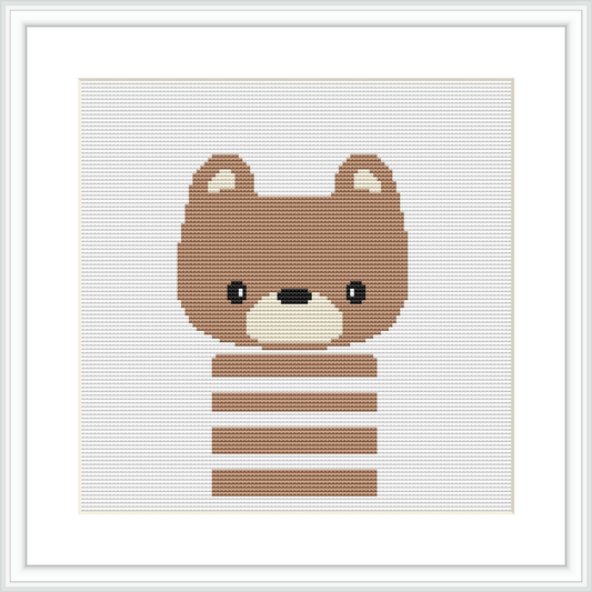 The image shows a cross stitch pattern framed in white, depicting a cute brown bear with a white snout and ears. The bear features horizontal stripes across its body and sits centered on a white background.