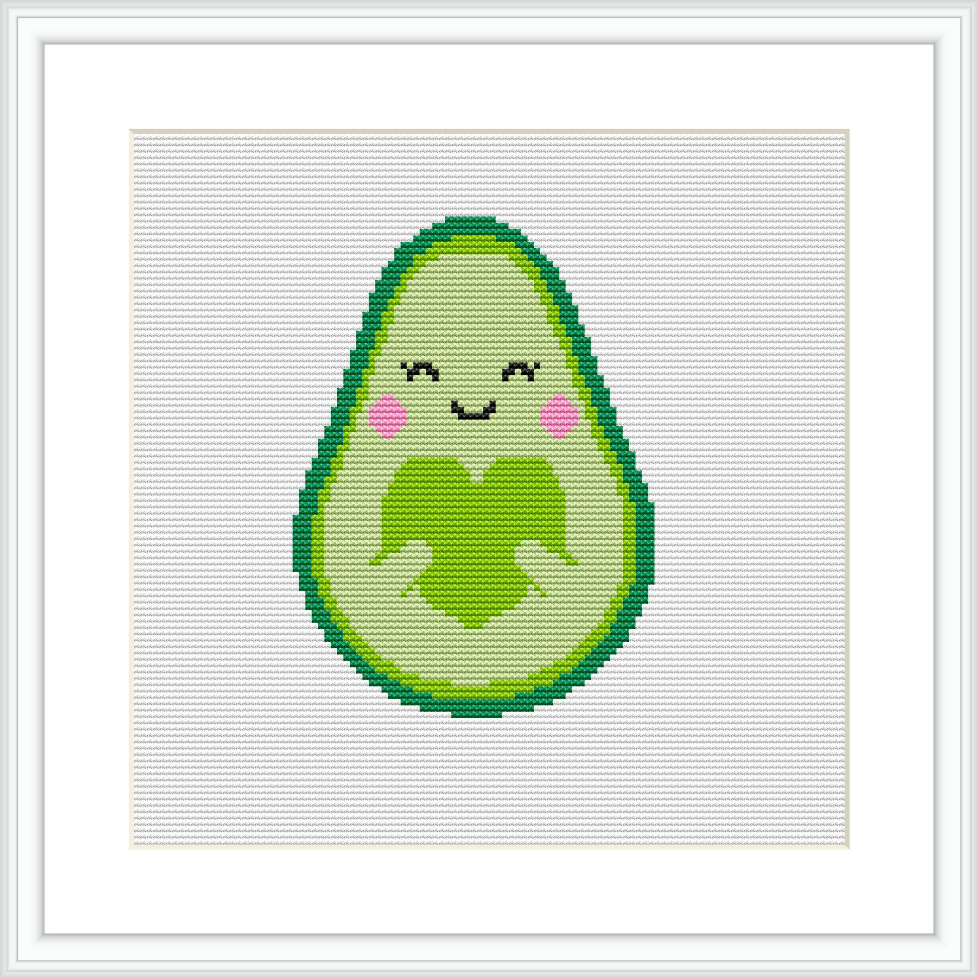 The image depicts a cross stitch pattern of a cute, smiling avocado with rosy cheeks and closed eyes. It's giving itself a hug with a simple green border outline.