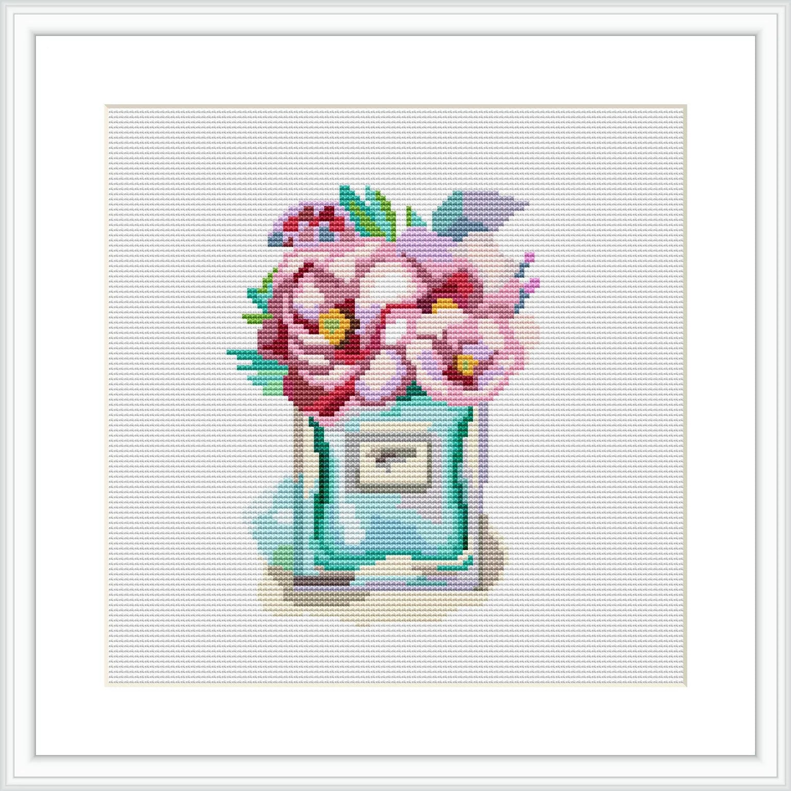 The image shows a cross stitch pattern of a perfume bottle with blooming flowers arranged on top. The bottle and flowers are highly stylized, with the stitching providing texture and depth to the design.