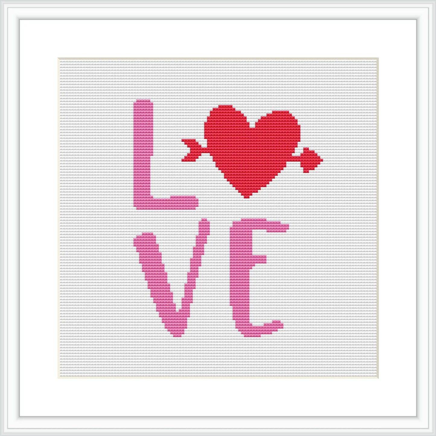 The image displays a framed cross stitch pattern with a white background. The central design features a large red heart with an arrow through it, above the word 'LOVE' spelled out in capital letters in a gradient of pink to red hues.