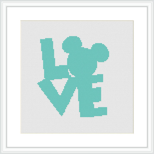 The image presents a framed cross stitch pattern with a design spelling the word 'LOVE', where the 'O' is replaced by the silhouette of a popular Disney character's head and ears. The design is set against a white background and exhibited in a simple, elegant frame.