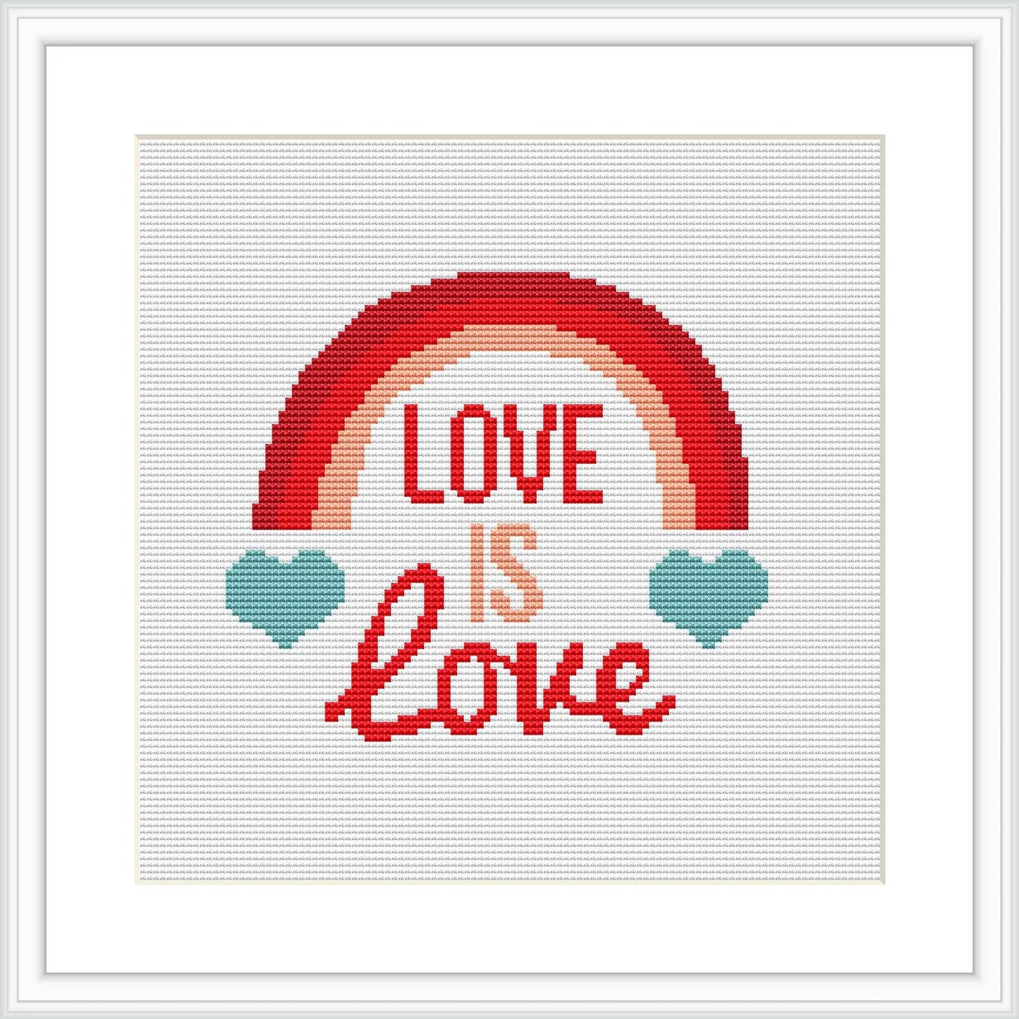 The image shows a framed cross stitch design with a rainbow arcing over the phrase 'LOVE IS LOVE', flanked by two teal hearts, against a white fabric background.