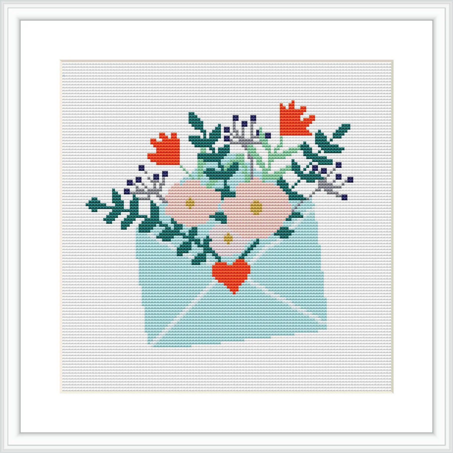 The image depicts a cross stitch pattern featuring an envelope in a soft pastel blue, with a variety of flowers blooming out of its open flap. The flowers include shades of pink, orange, and lavender with green leaves. There is a small red heart in the center of the arrangement, and the envelope appears to be on a plain, lightly shaded background within a square frame.