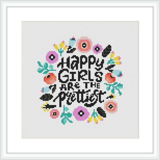 The image showcases a cross stitch embroidery pattern featuring the phrase 'Happy Girls are the Prettiest' surrounded by a wreath of stylized flowers and leaves. The pattern is designed within an 8x8 inches square, indicating a medium-sized project.