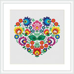 The image shows a framed cross stitch pattern featuring a heart shape filled with various colorful flowers, all of which are stitched on a white background.