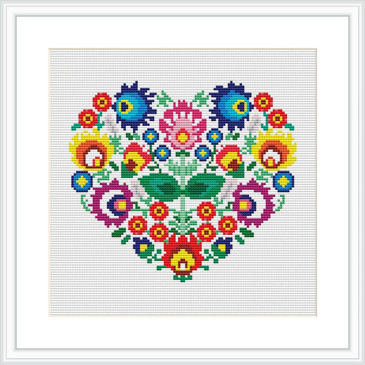 The image shows a framed cross stitch pattern featuring a heart shape filled with various colorful flowers, all of which are stitched on a white background.