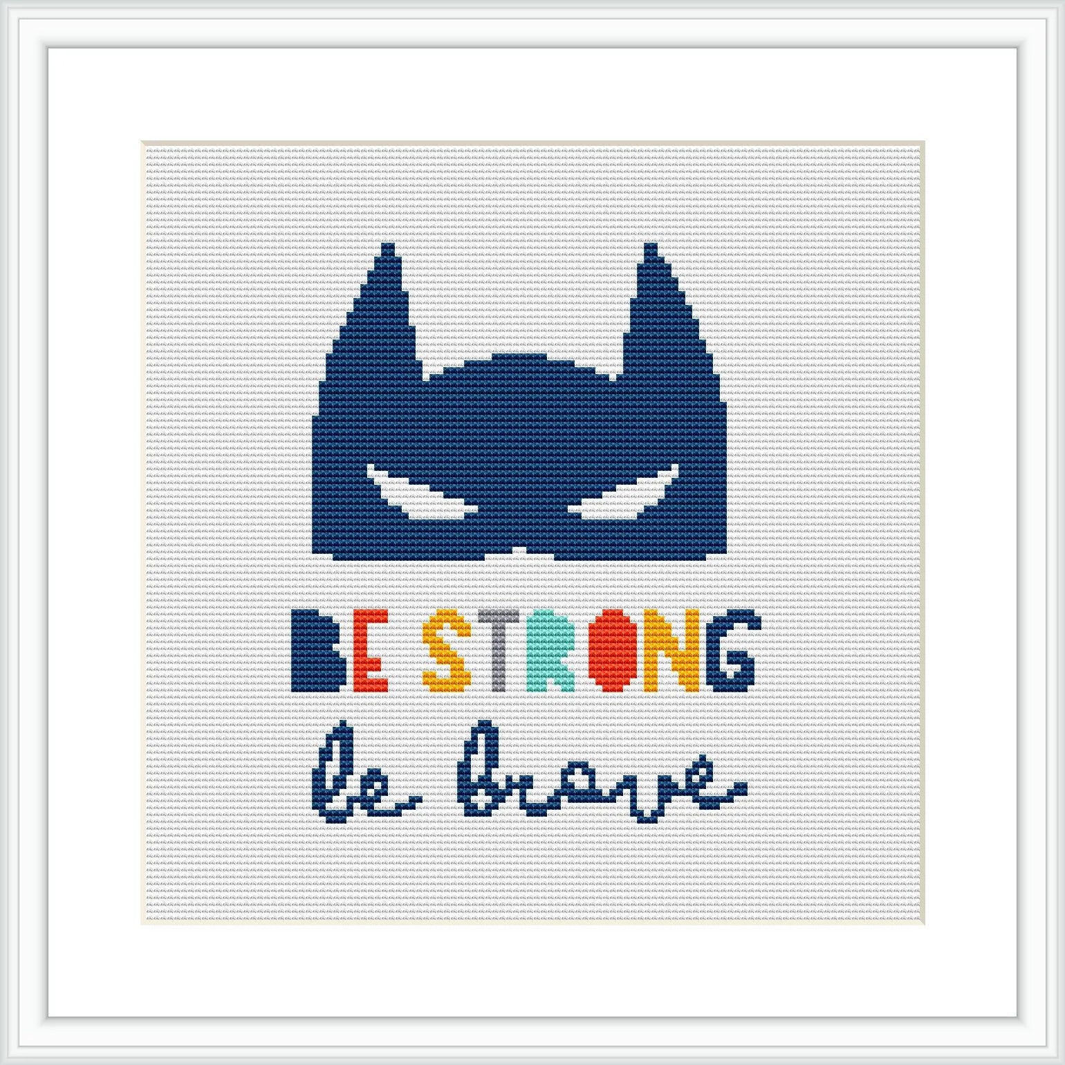 The image depicts a framed cross stitch pattern with the silhouette of a superhero mask in navy blue at the top. Below the mask, the words 'BE STRONG be brave' are stitched in a rainbow of colors, each letter in a different hue.