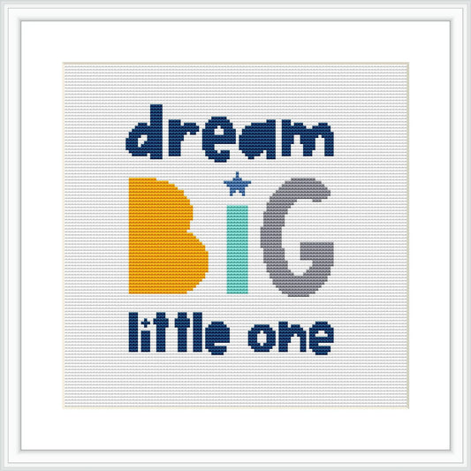 The image showcases a framed cross stitch pattern with the phrase 'dream BIG little one' centered on a white Aida cloth. The word 'BIG' is emphasized with larger, bold letters, while 'dream' and 'little one' are in a smaller font. The text is complemented by a star motif.