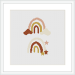 The image showcases a cross stitch pattern with two stylized rainbows placed above a cloud formation. Warm and neutral tones dominate the color palette. Minimal use of backstitch creates defined edges.