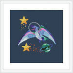 The image depicts a cross stitch pattern featuring a cartoon dinosaur wearing a space helmet and drifting through space with stars and a constellation around it.