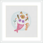 The image displays a framed cross stitch pattern of a cat with mermaid tail and fins, holding a seashell and a jellyfish, with a stylized underwater backdrop including bubbles and a coral branch.