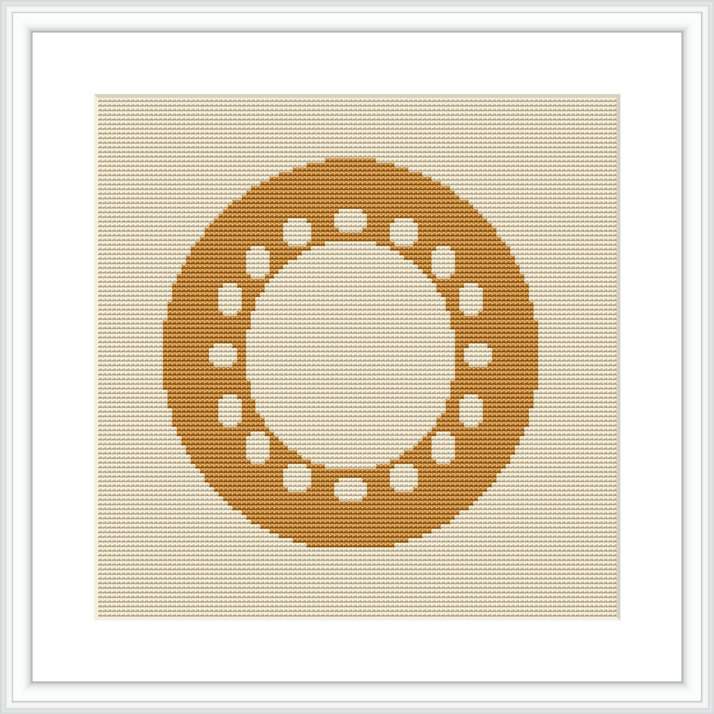 The image displays a framed cross stitch pattern hanging on a wall. The design depicts a centered circular motif made up of small geometric shapes, predominantly in shades of yellow, on an ecru or light beige aida cloth.